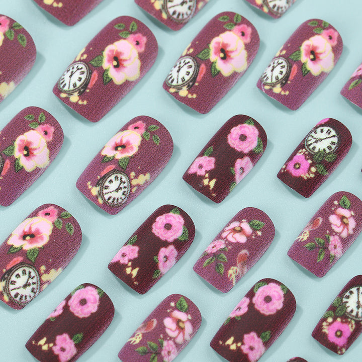 Nail art with floral design and intricate clock motifs Kalsten