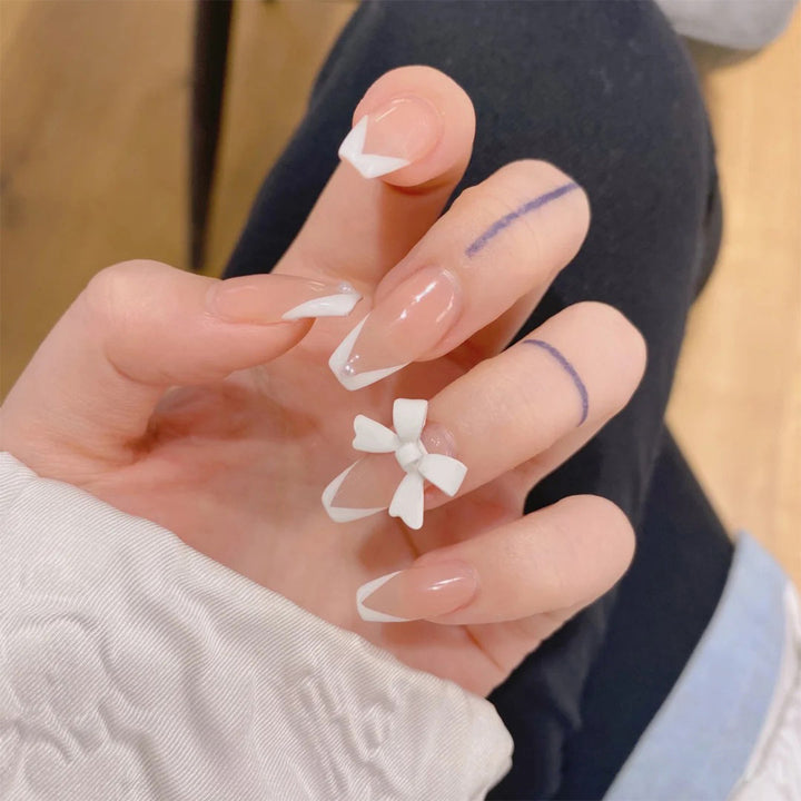 Elegant artificial nails with translucent French tip and decorative floral accents Kalsten