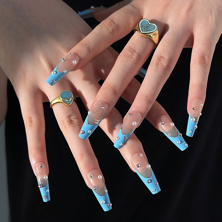 Artificial nail extensions with glitter and pearl accents Kalsten