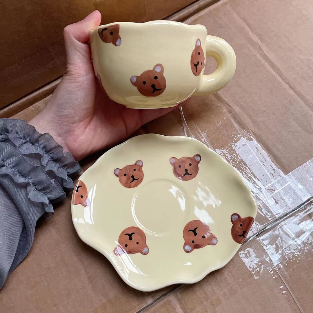 Ceramic coffee set with playful bear reliefs and organic wave saucer