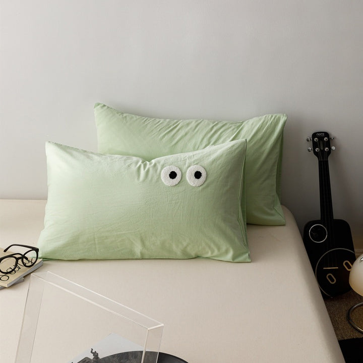 Playful cushion cover set with embroidered eye appliqués made of soft cotton fabric