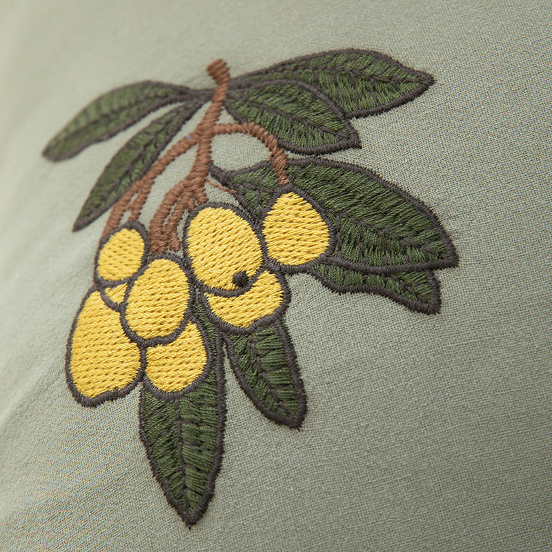 Square decorative pillow with ruffled edges and hand-stitched flower appliqués