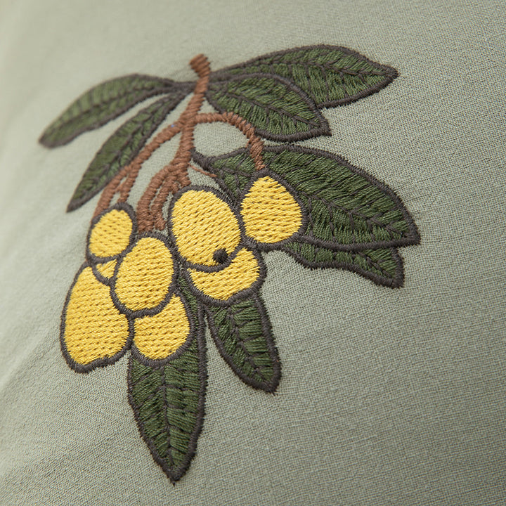 Square decorative pillow with ruffled edges and hand-stitched flower appliqués