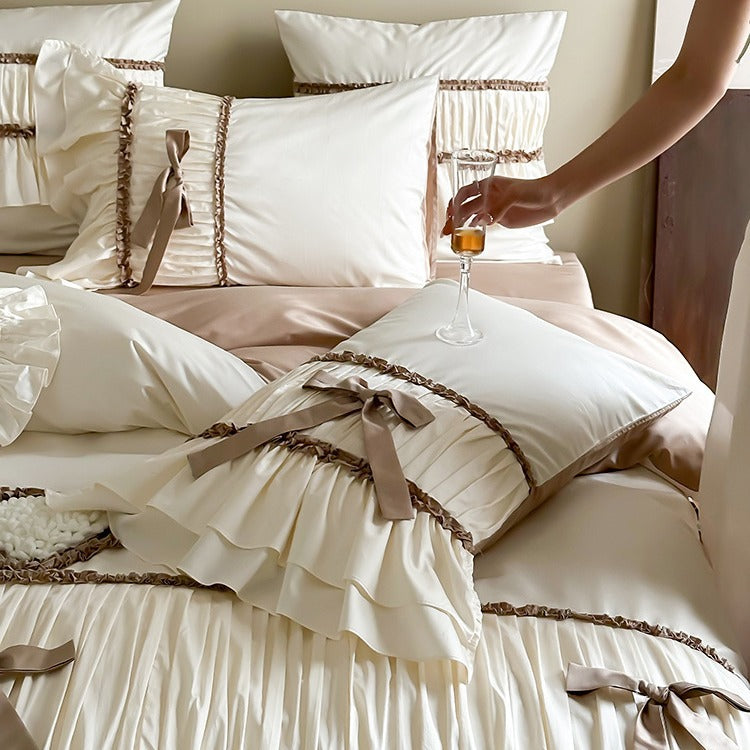 Pleated bed linen set with ruffle, decorative ribbons and bow accents