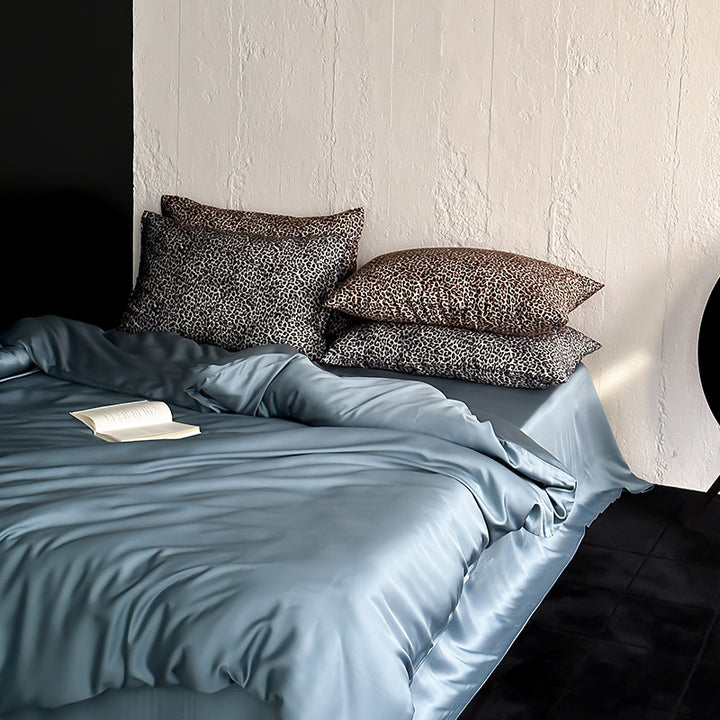 Satin bedding set with a silky sheen, smooth drape, and animal print pillows