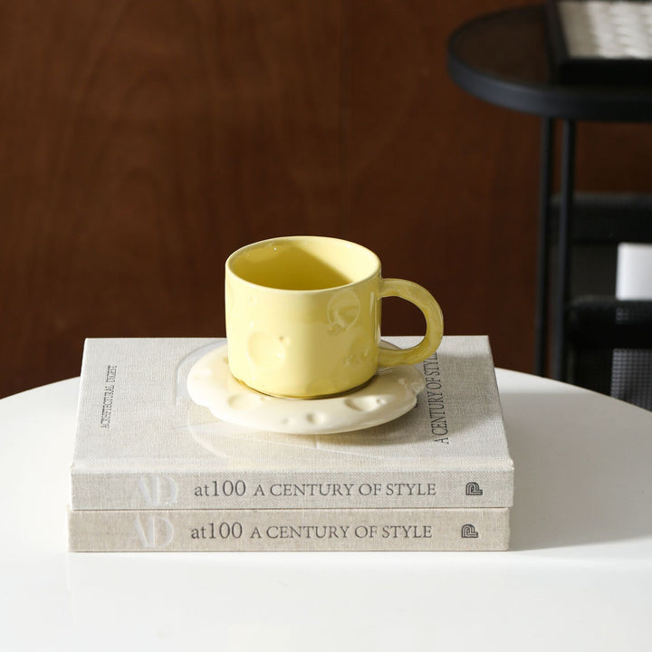 Ceramic coffee cup set with textured relief surface and wavy saucer