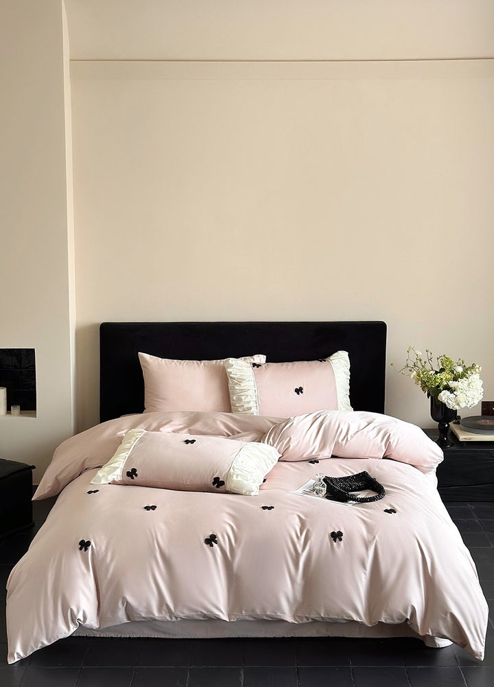 Luxurious cotton satin bedding set with embroidered bows and ruffle details