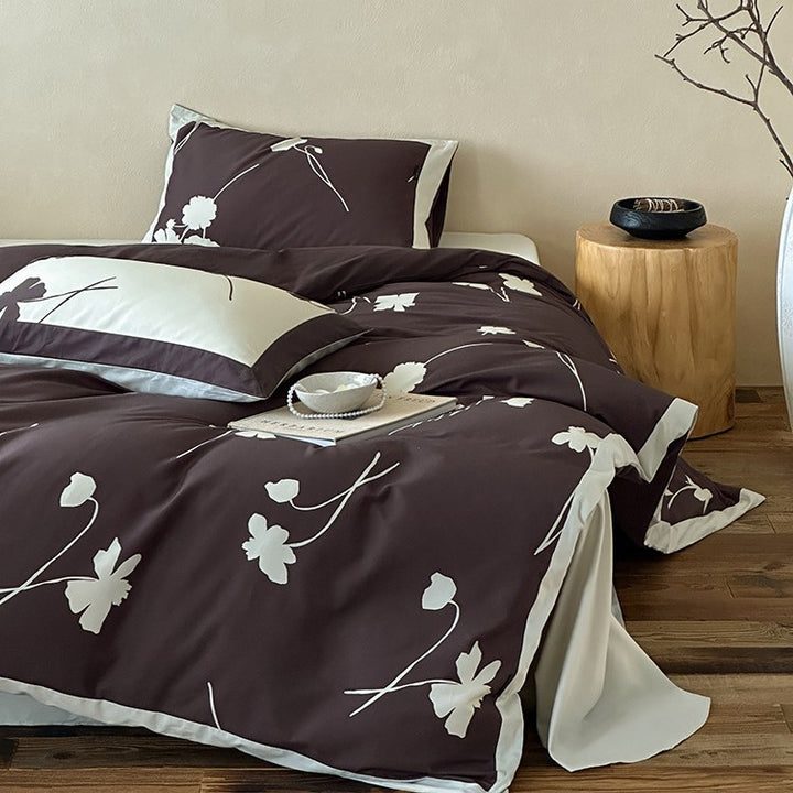 Reversible cotton satin bedding set with floral silhouette print and contrasting piped edge
