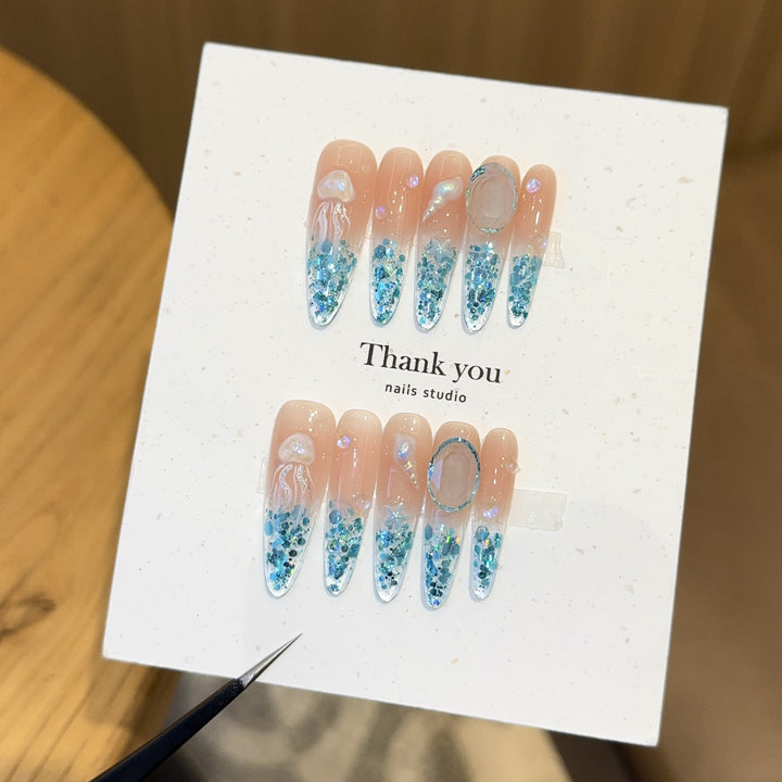 Creative artificial nails with maritime designs and sparkling accents Kalsten