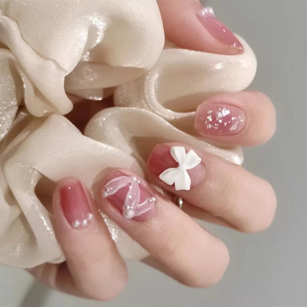 Glamorous nail art with pearl and bow accents Kalsten