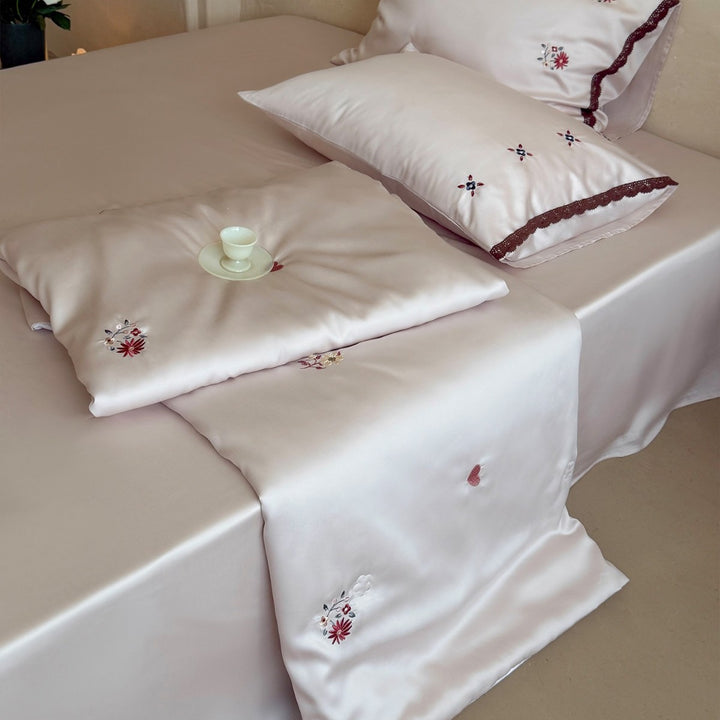Elegant satin bedding set with fine floral embroidery and lace trim