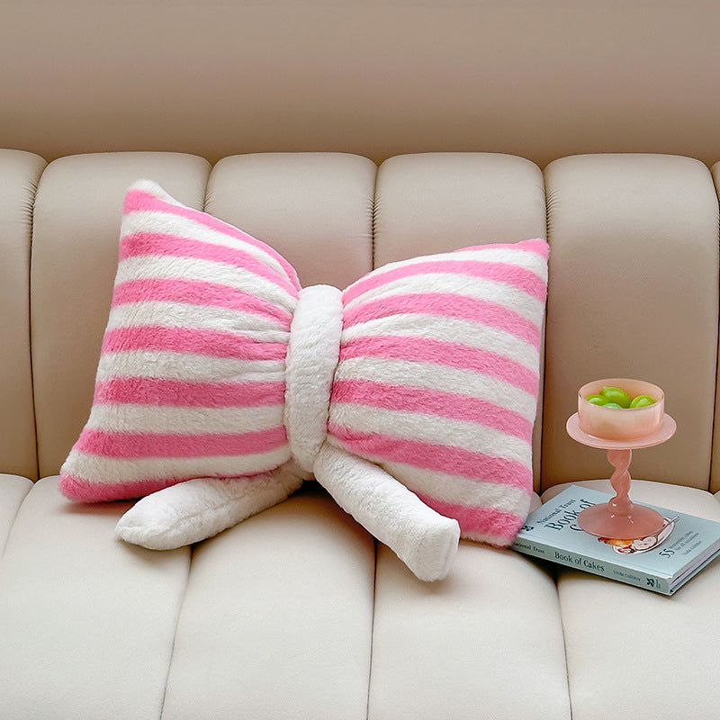 Cuddle cushion in bow shape made of plush with striped texture