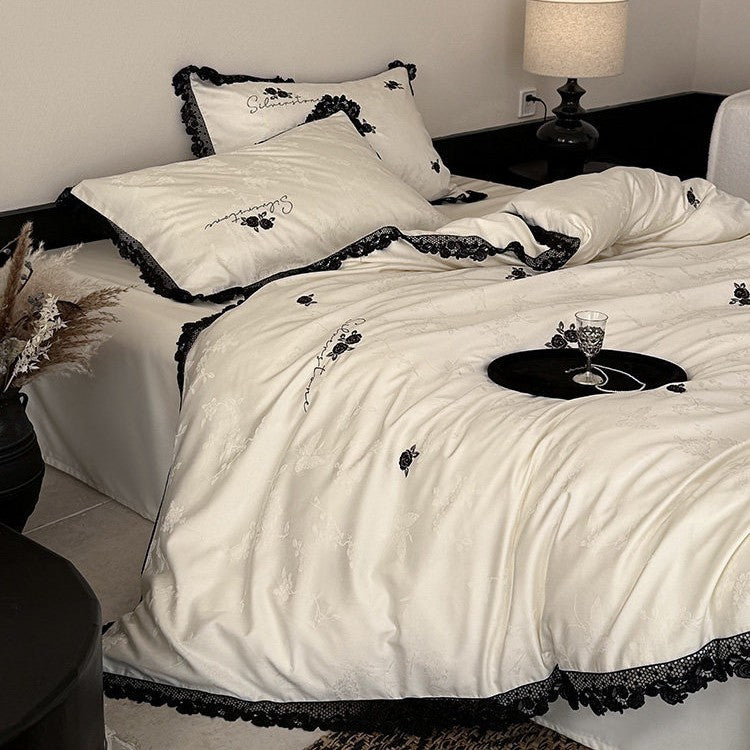 Luxurious satin bedding set with black lace trim and embroidered rose appliqués