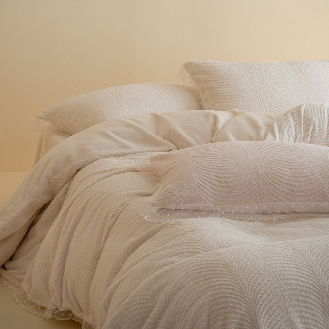 Quilted bedding set with lace edge and wave quilting pattern
