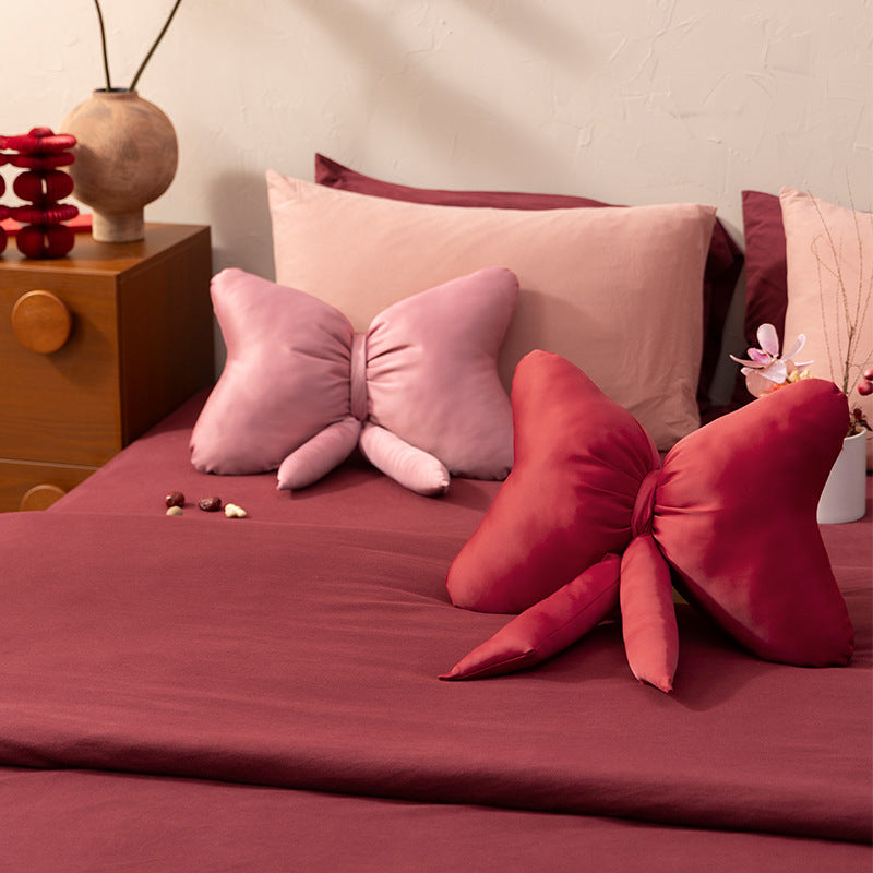 Bow-shaped decorative pillow with soft microfiber cover and decorative ribbons