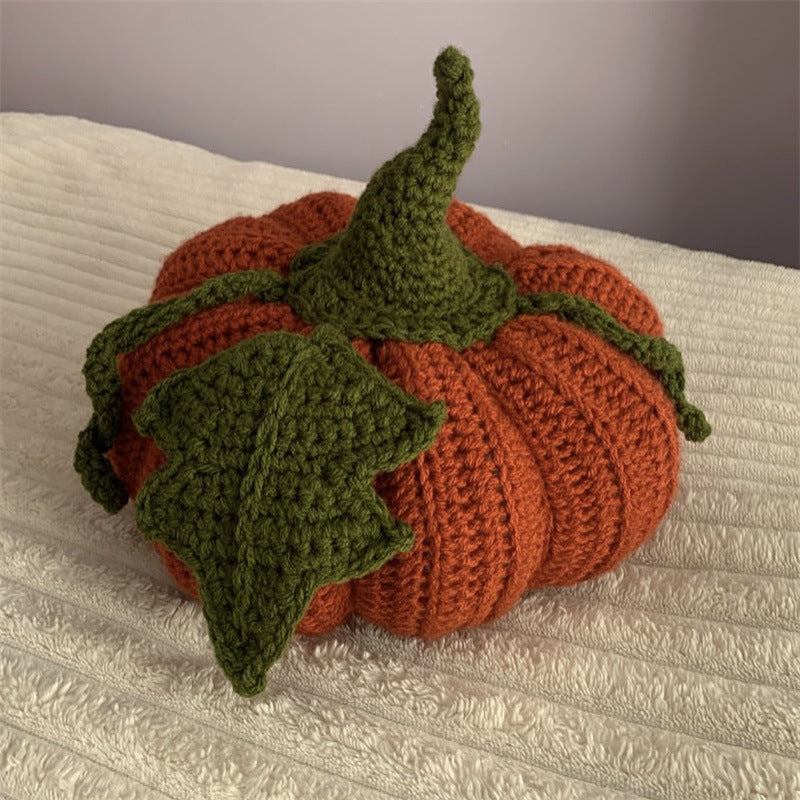 Hand-crocheted decorative cushion in pumpkin shape with leaf and vine application