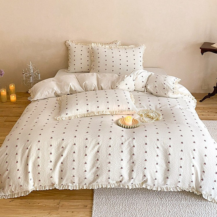 Quilted bedding set made of cotton muslin with delicate cherry print and ruffle edge