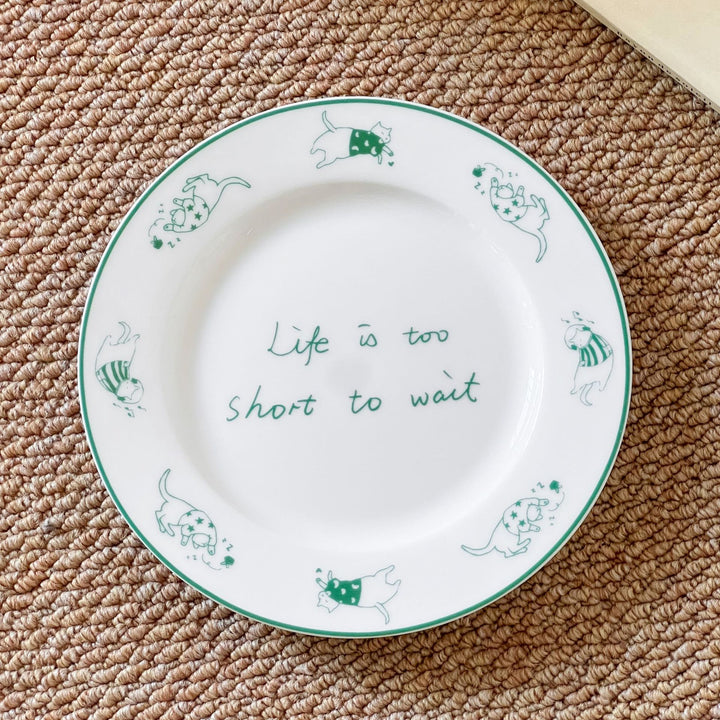 Decorative ceramic plate with cat motif and green border decoration