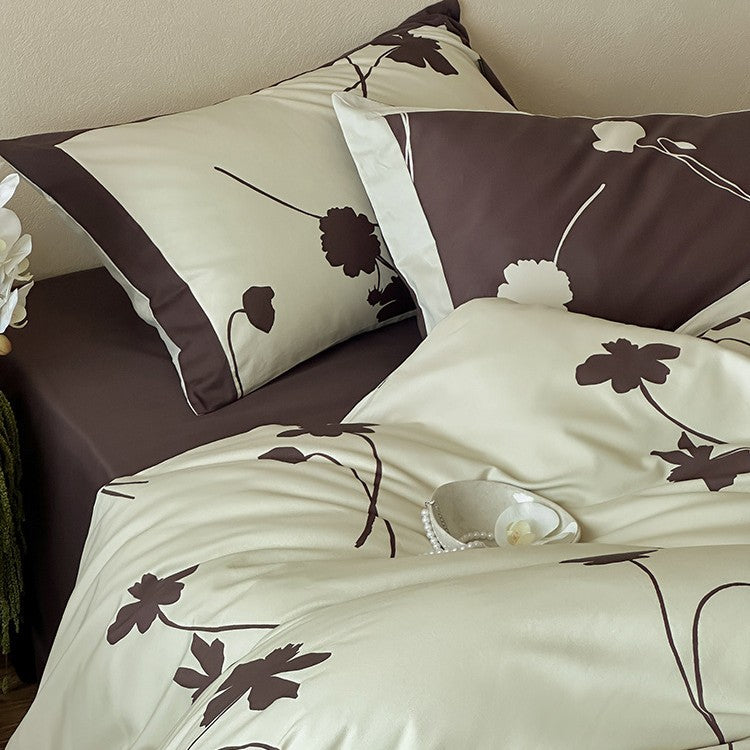 Reversible cotton satin bedding set with floral silhouette print and contrasting piped edge