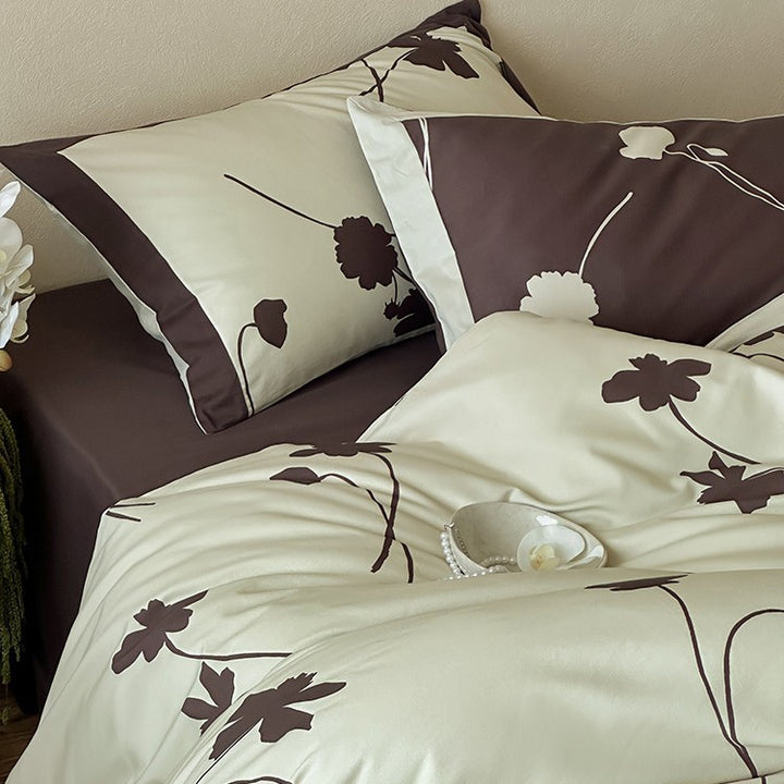 Reversible cotton satin bedding set with floral silhouette print and contrasting piped edge