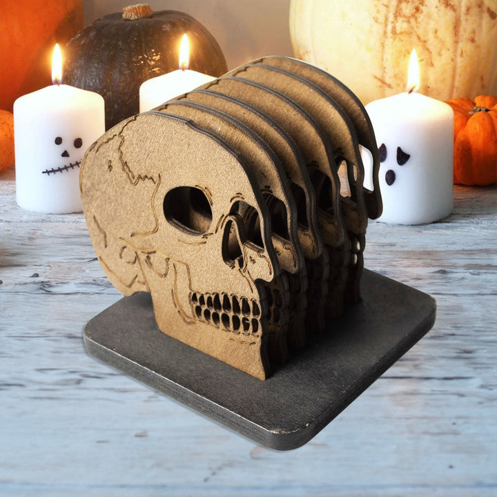 Set of laser-engraved wooden coasters in skull shape with storage stand