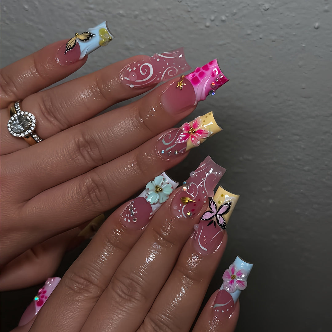 Artistic nails with floral accents and glitter clusters Kalsten