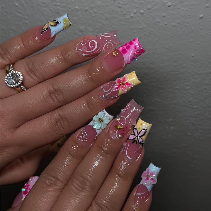 Artistic nails with floral accents and glitter clusters Kalsten