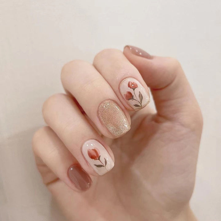 Artificial nail art with colorful flower design and glitter accents Kalsten