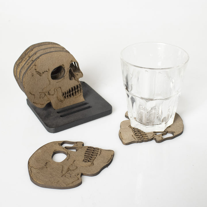 Set of laser-engraved wooden coasters in skull shape with storage stand