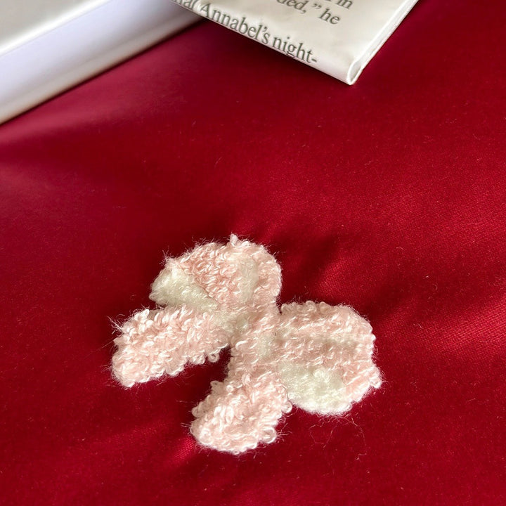 Luxurious cotton satin bedding set with embroidered bows and ruffle details