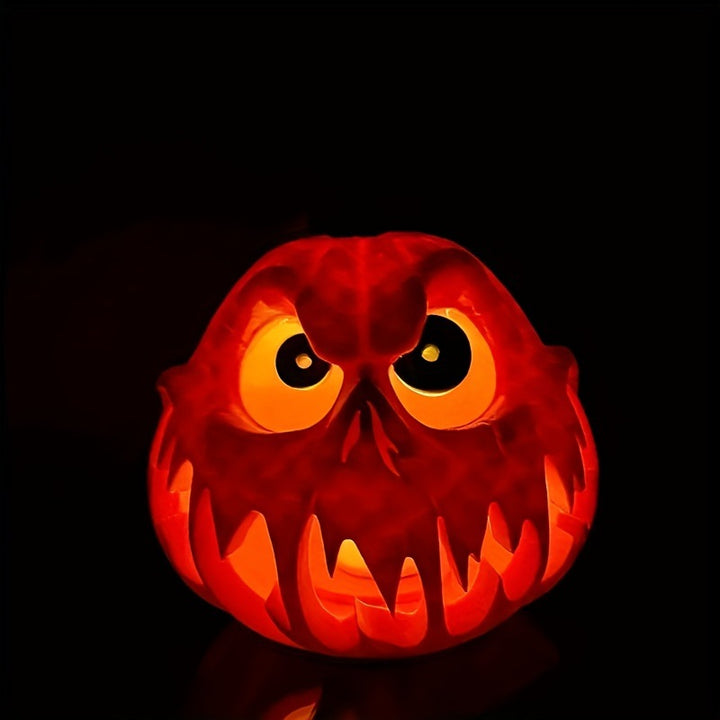 Ceramic pumpkin lantern with hollowed-out spooky face and tealight compartment
