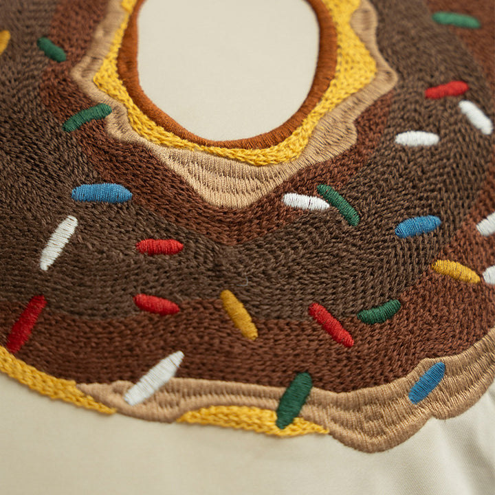 Square decorative pillow cover with hand-embroidered donut appliqué and piping Kalsten