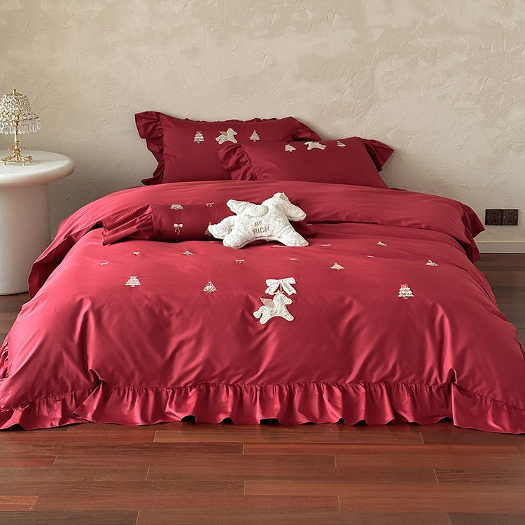 Festive satin bedding set with embroidered pine and mythical creature appliqués and ruffled cushion