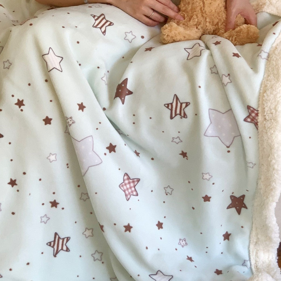 Reversible fleece blanket with cartoon cat design and teddy lining