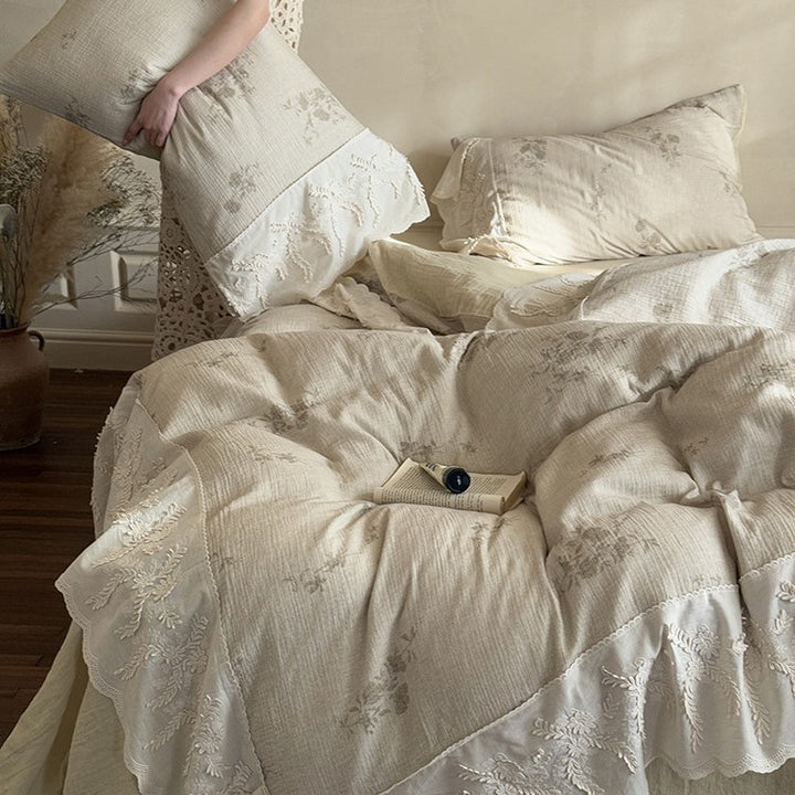 Quilted duvet with embroidered ruffle and delicate pillowcases