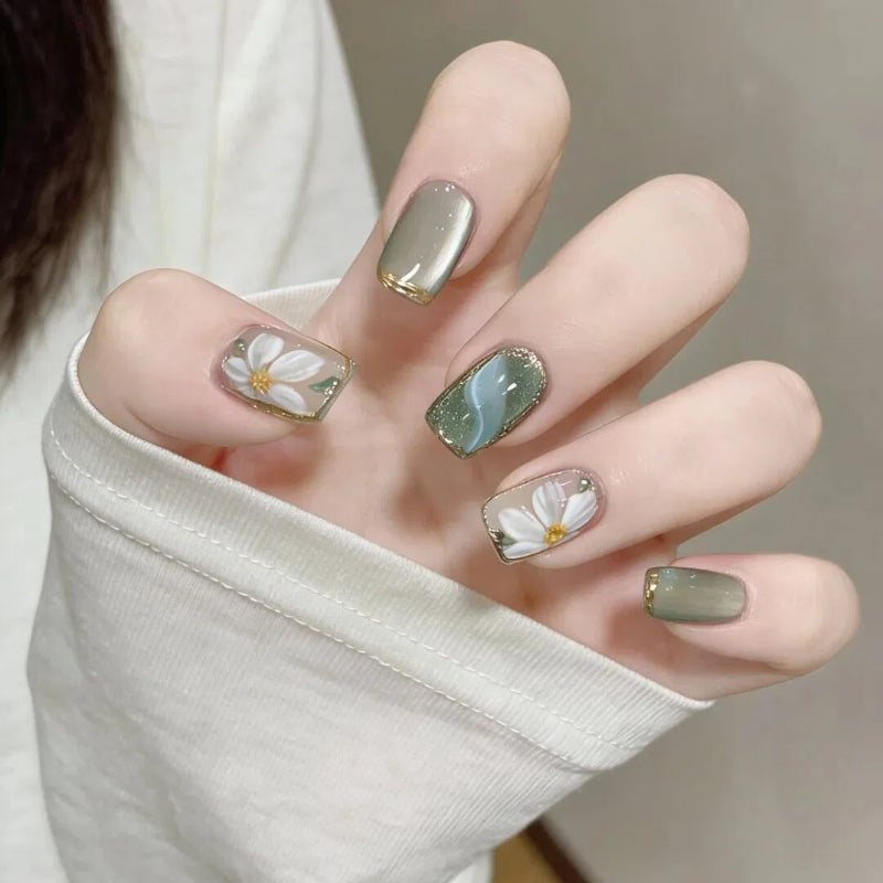 Artificial nails with floral accents and glamorous gold trim Kalsten