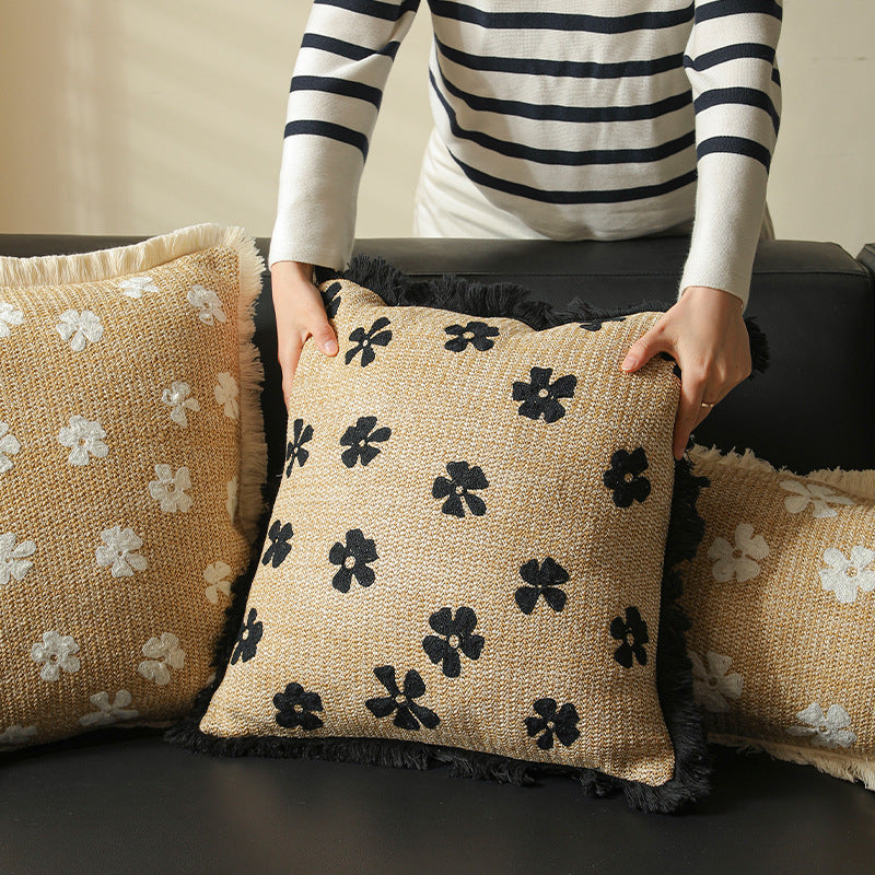 Rectangular woven decorative pillow with contrasting flower tufting and fringe trim