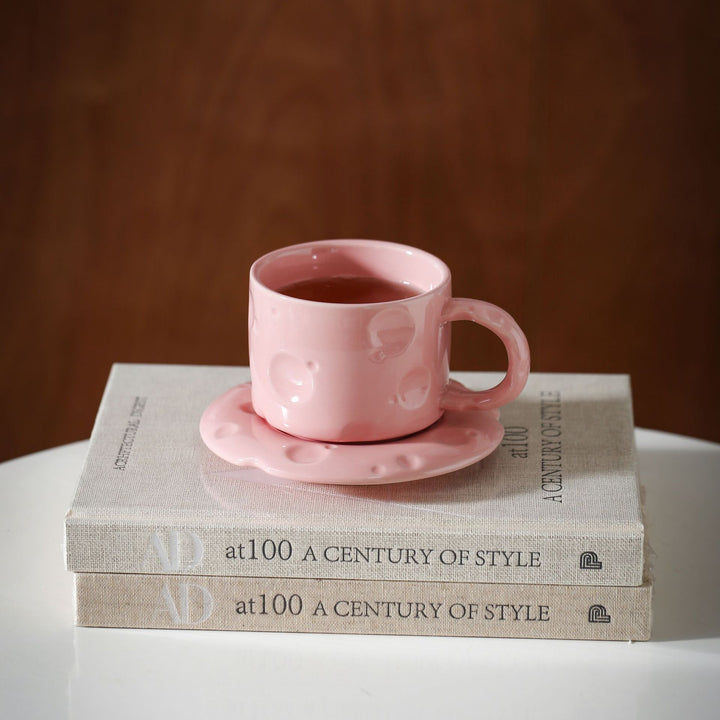 Ceramic coffee cup set with textured relief surface and wavy saucer