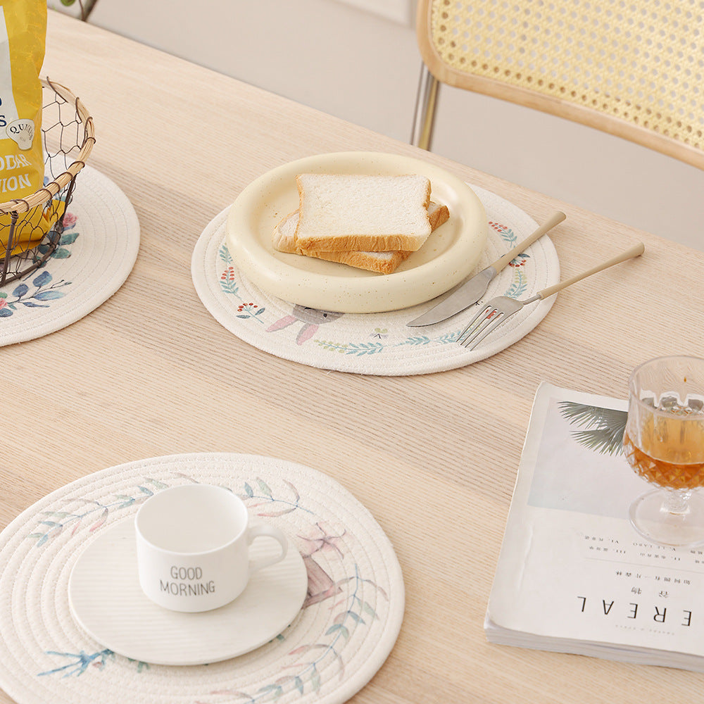 Round placemat made of woven cotton with a cute rhinoceros illustration and floral wreath Kalsten