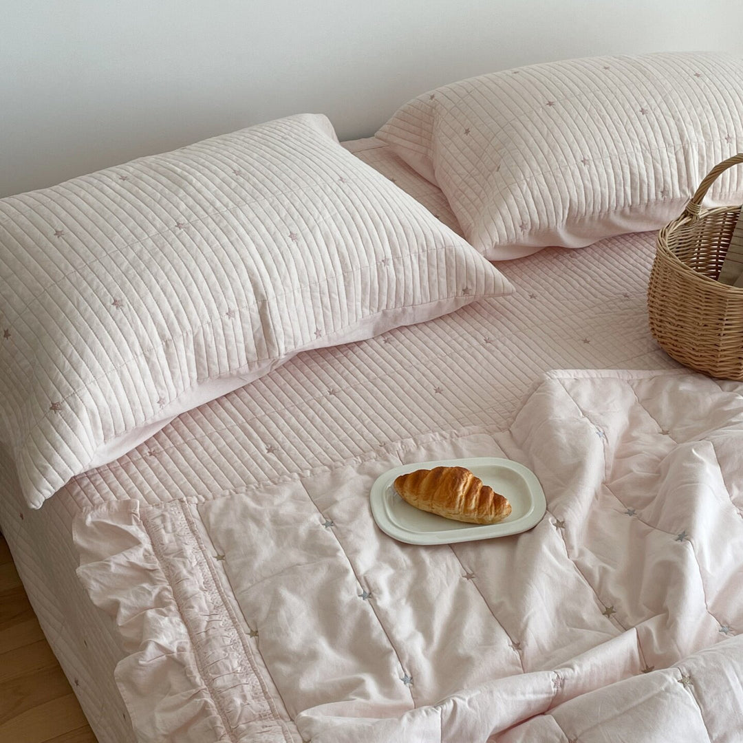 Quilted bedspread with delicate longitudinal stitching and matching pillowcases