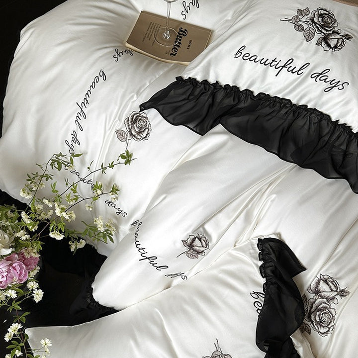 Bedding set made of silky-soft cotton satin with ruffle, delicate rose embroidery, and decorative lettering