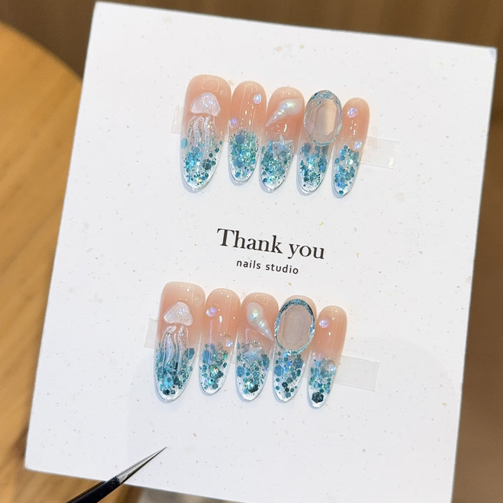 Creative artificial nails with maritime designs and sparkling accents Kalsten