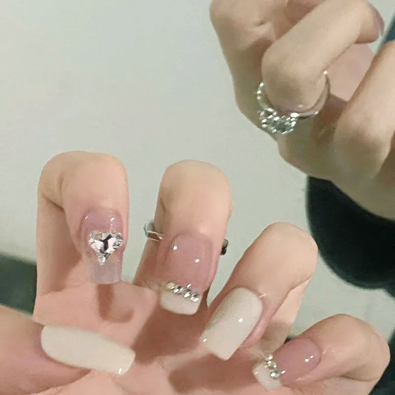 Glamorous artificial nails with heart and rhinestone decorations Kalsten