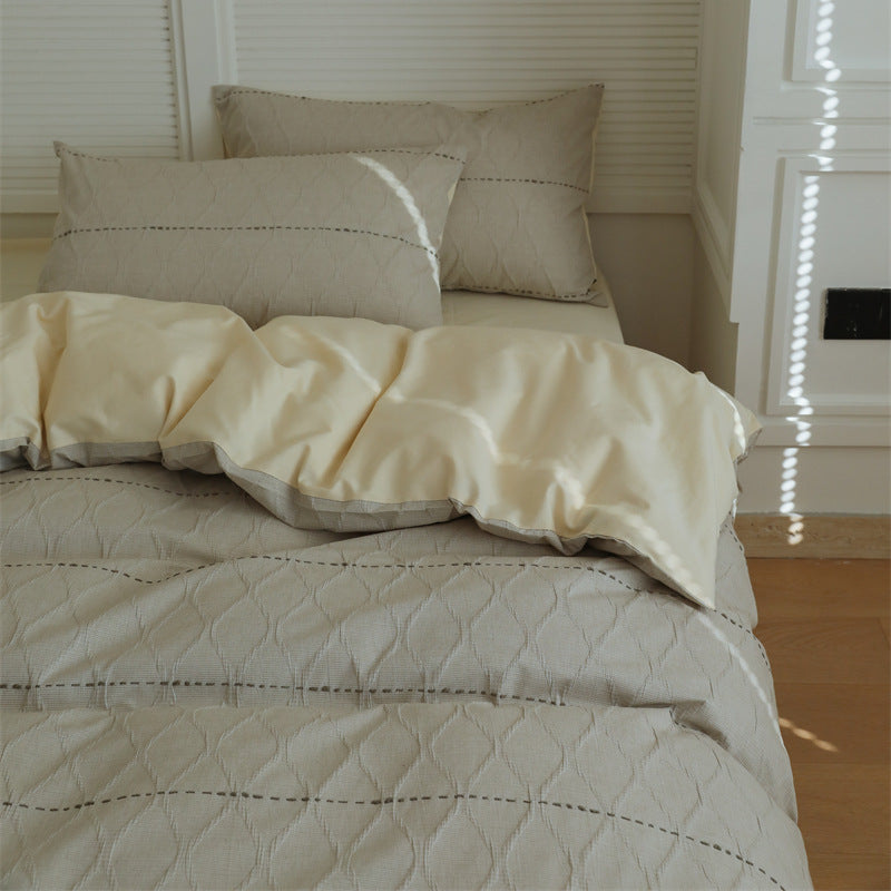 Reversible quilted bedding set made of cotton blend with textured leaf quilting and satin finish back