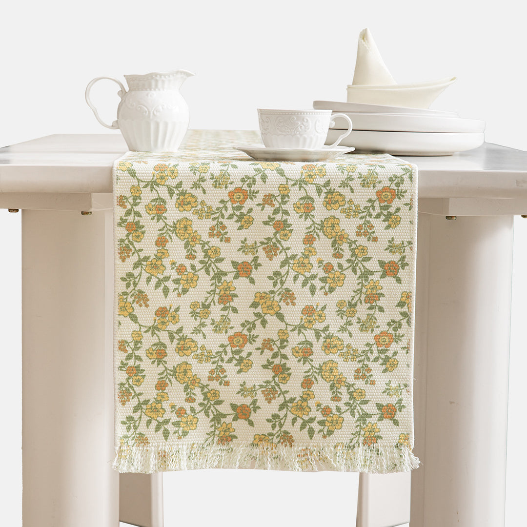 Woven table runner with flower jacquard, fringes and cotton blend