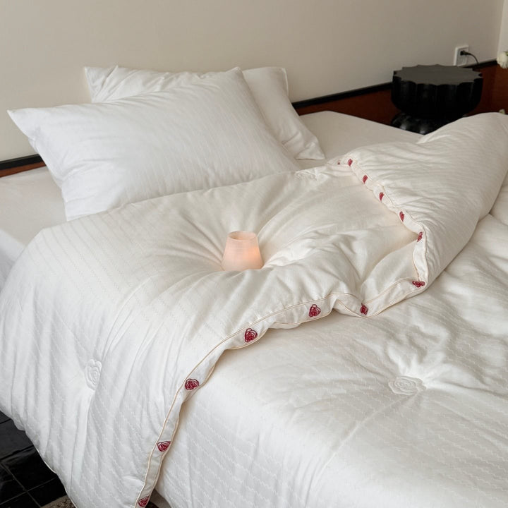 Quilt made of cotton satin with embroidered rose trim