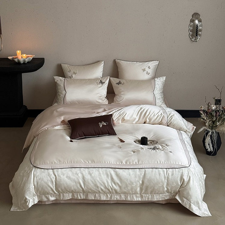 Luxurious satin bedding set with embroidered butterflies, decorative pillows, and tassels