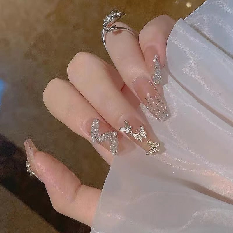 Glamorous nail art with rhinestone and butterfly elements Kalsten