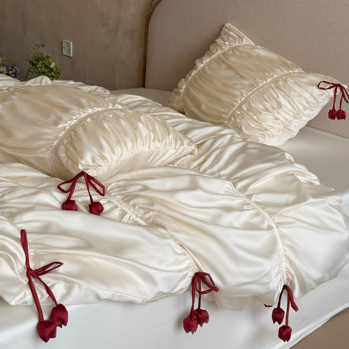 Satin bedding set with gathered drawstring look and tassels