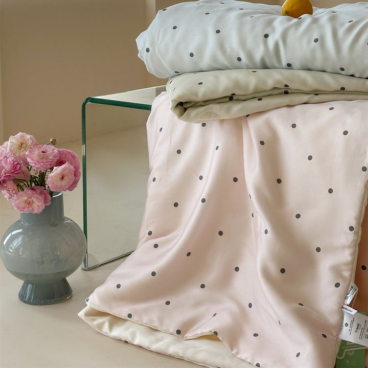 Luxurious satin bedding set with polka dot pattern and pom-pom tassels